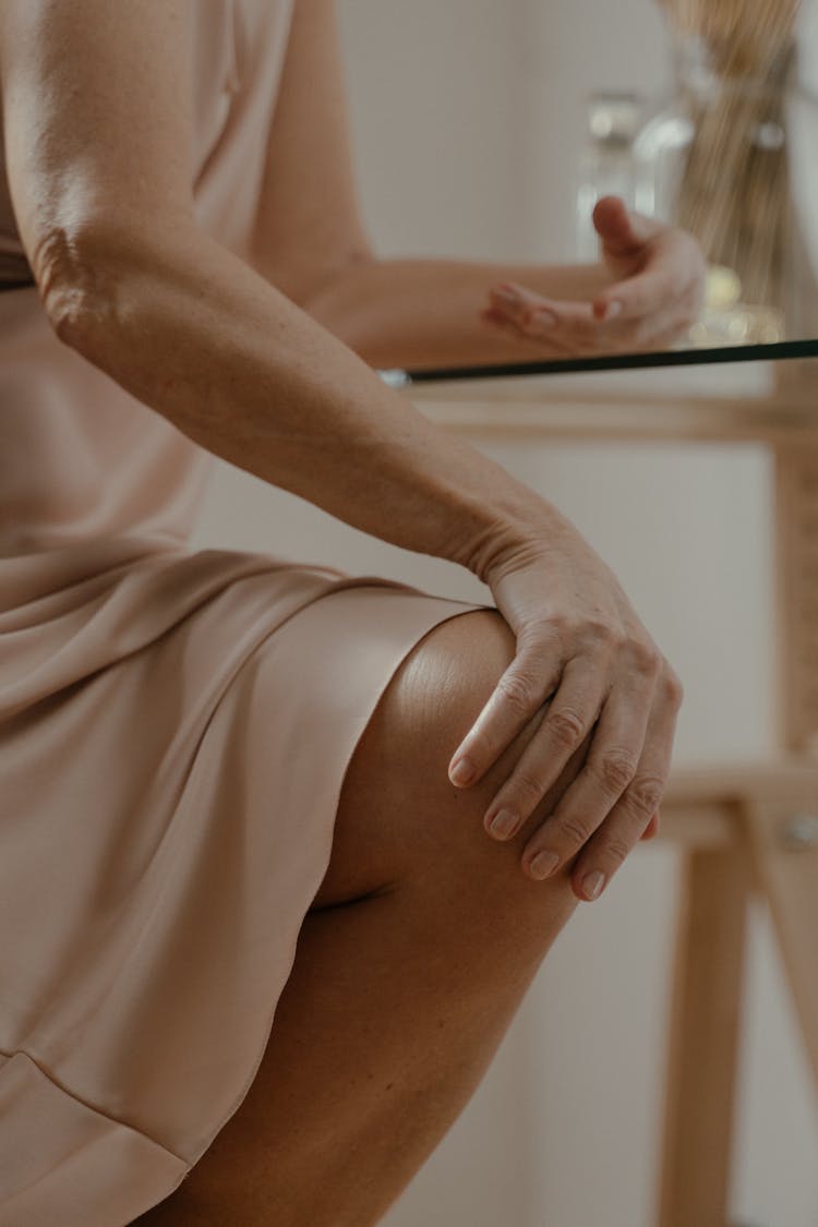 Close-Up Photo Of A Person's Hand Touching Her Knee