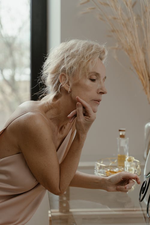 Elegant Elderly Woman leaning on Glass Table 