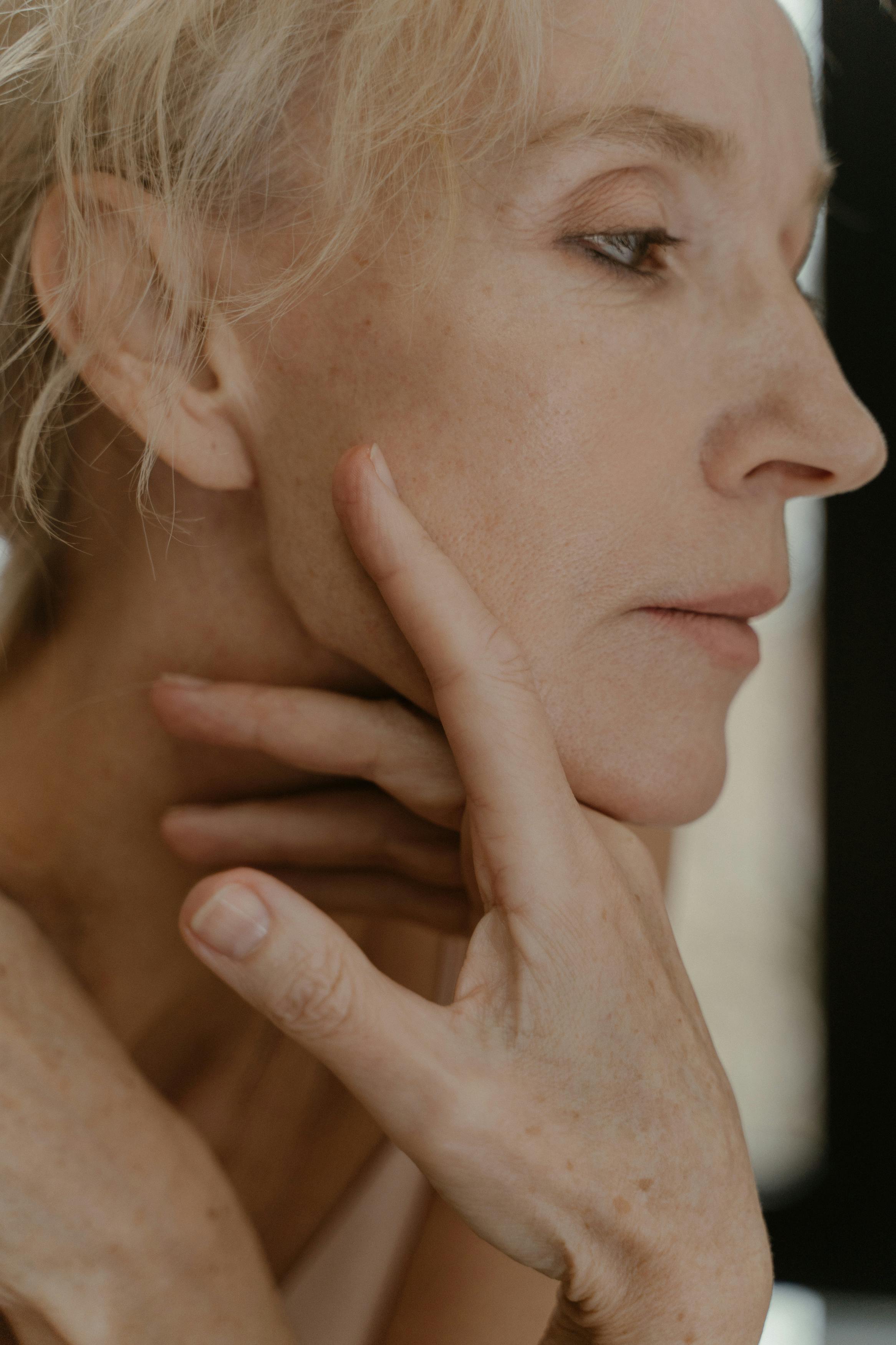 A graceful senior woman in a side profile portrait, exuding elegance and wisdom.