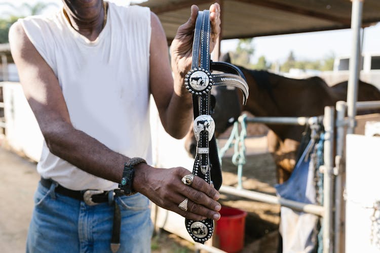 Person Holding A Leather Saddle 