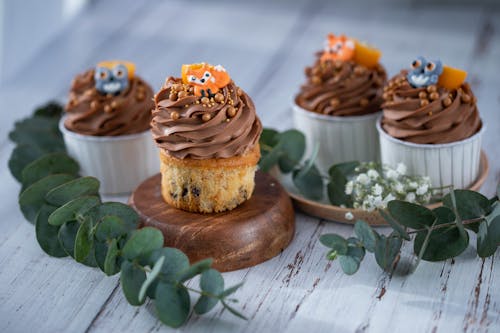 Cupcakes with Chocolate Cream and Decoration on Table