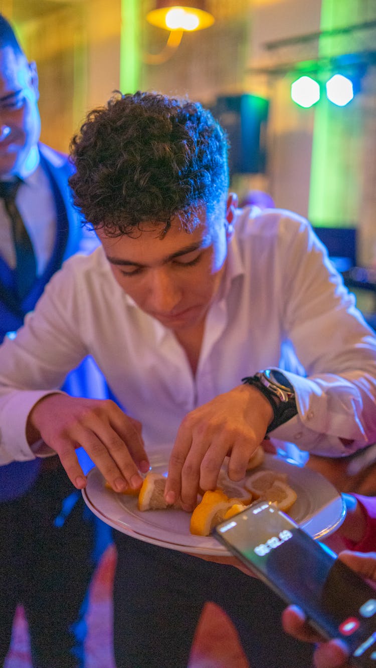 Man At Party Eating Lemon Slices