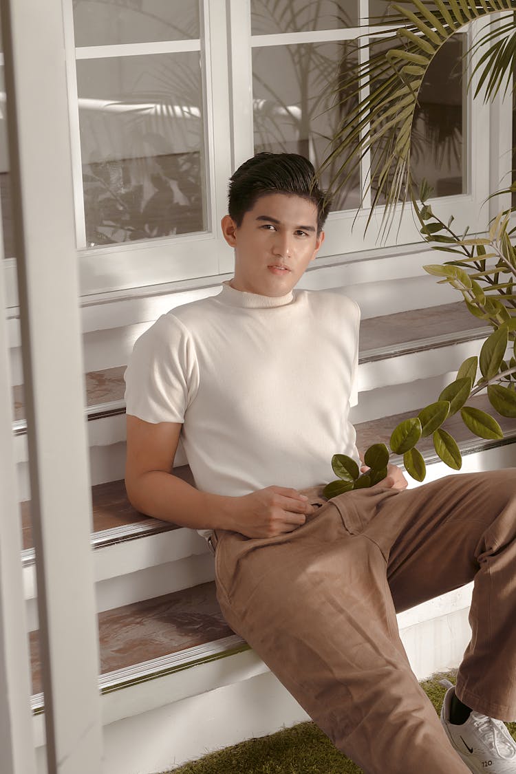 Young Man Sitting On Steps By The Front Door 