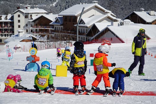 Kids in colorful outfits enjoying ski lessons on a snowy slope