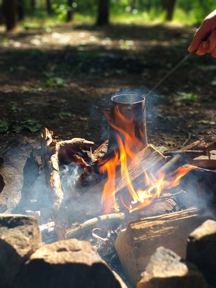 Person Boiling Water Over The Campfire 