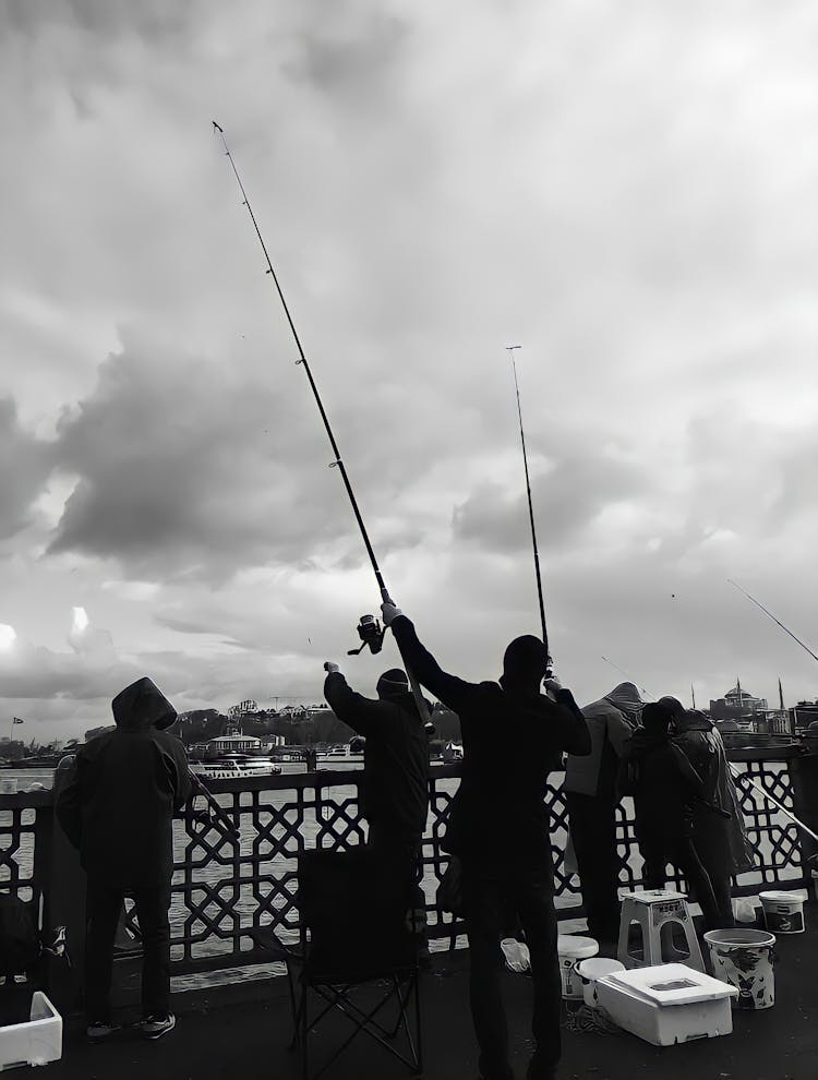 People With Rods Fishing From Bridge