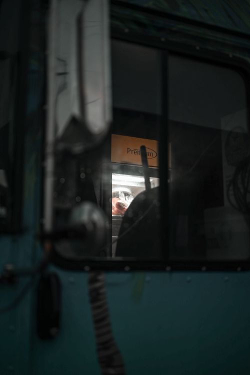 Free A dimly lit close-up of a bus window with reflections, creating a moody atmosphere. Stock Photo
