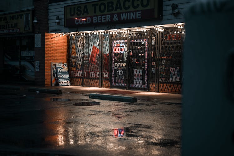 
A Wet Parking In Front Of A Closed Store At Night