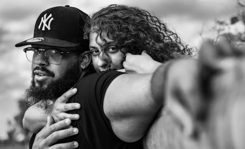 
A Grayscale of a Woman Hugging a Man