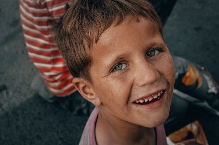 
A Close-Up Shot Of A Smiling Boy With A Dirty Face