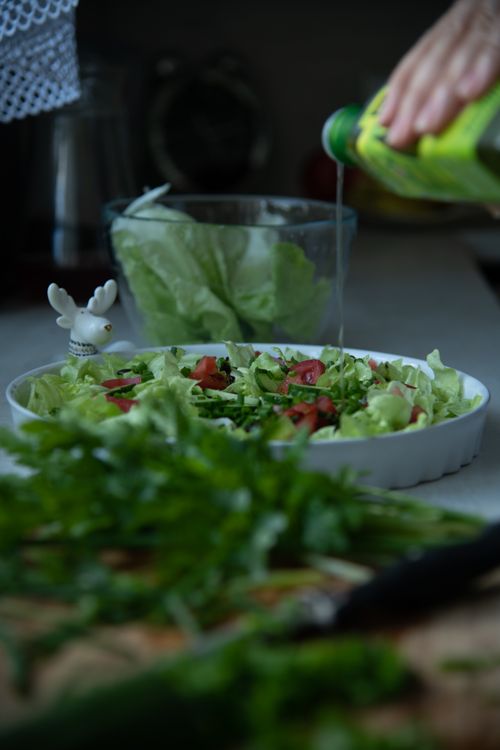 Free Close-up of fresh organic salad preparation with olive oil pouring, showcasing a vibrant and healthy dish. Stock Photo