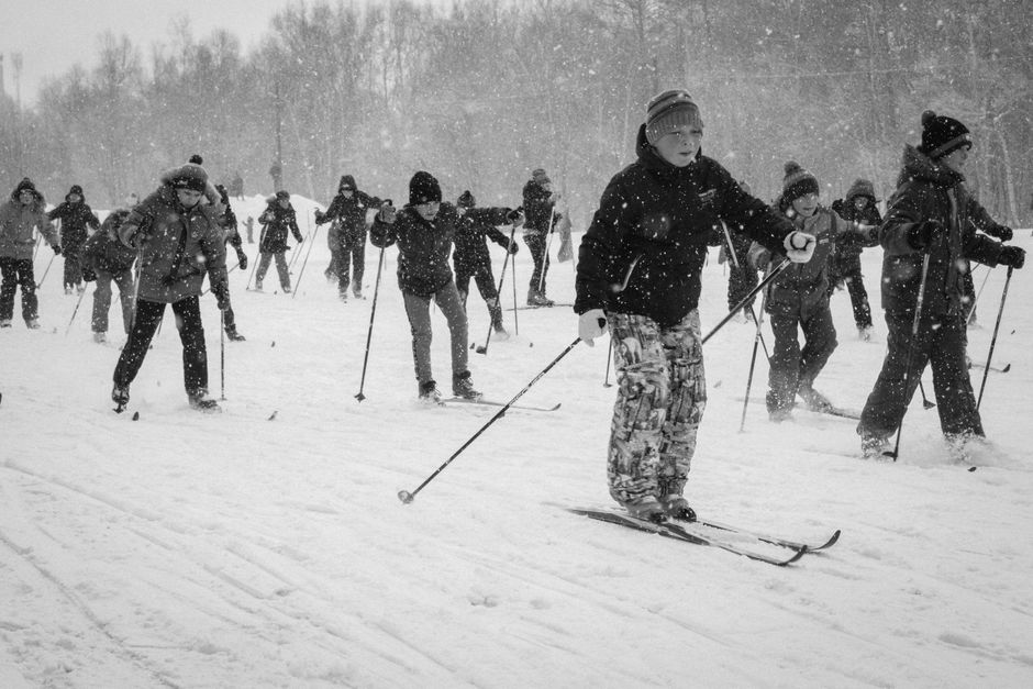 A group of youth skiing together in a snowstorm, capturing the excitement and challenge of winter sports.