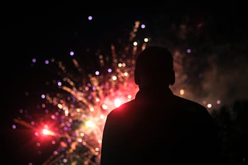 Silhouette of a Person Watching Fireworks