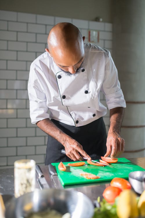 A Chef Slicing Tomatoes