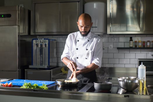 Chef preparing a dish in a modern kitchen setting, highlighting culinary skill.