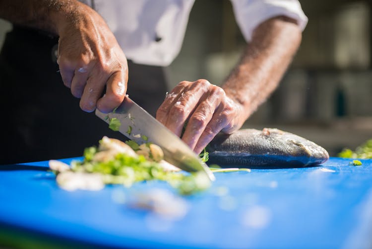 A Chef Slicing A Fish Using A Knife