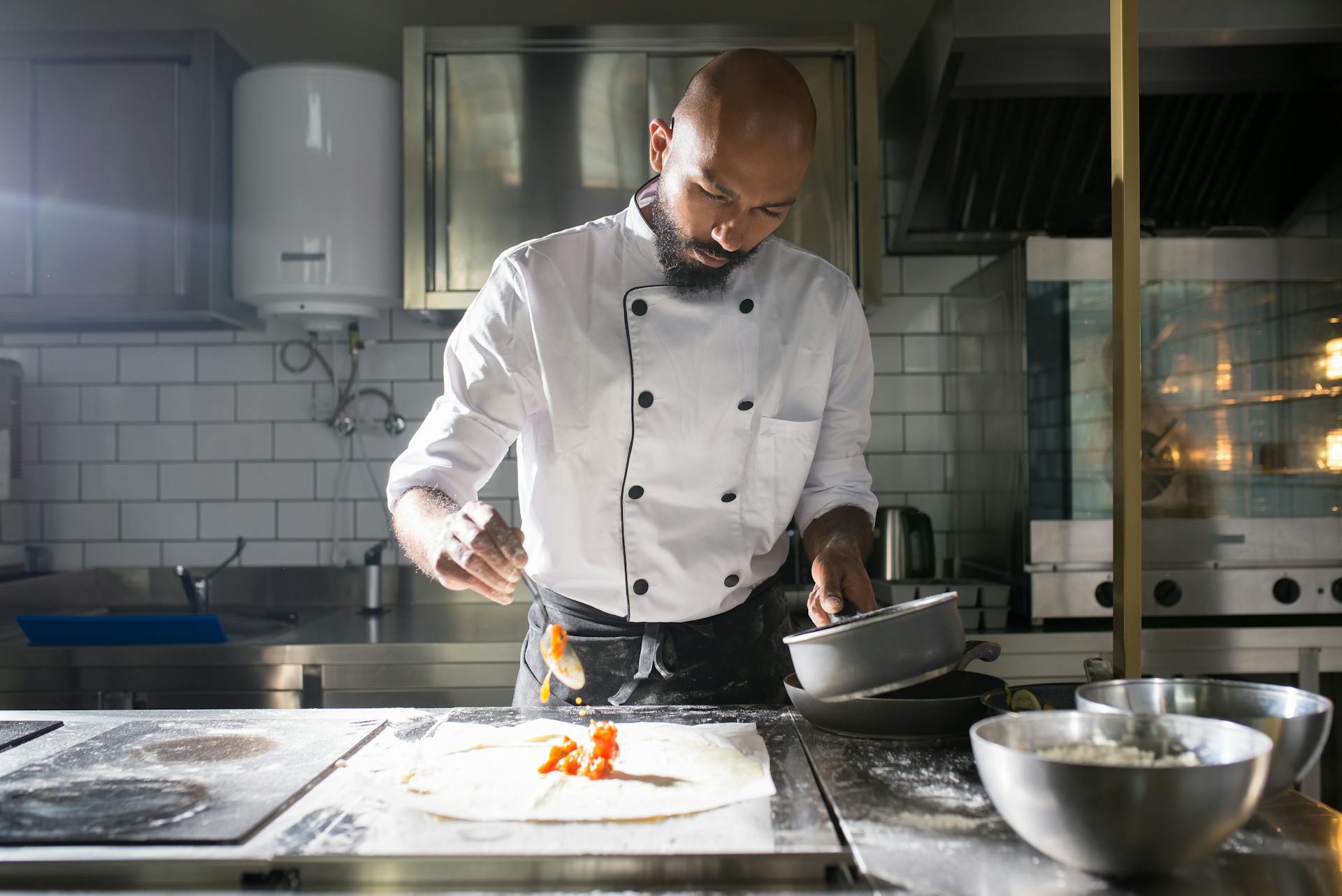 A Man in White Chef Uniform Cooking in the Kitchen