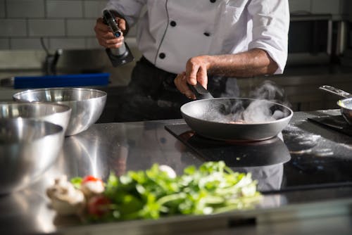 A Person Cooking Over the Stove Using a Frying Pan