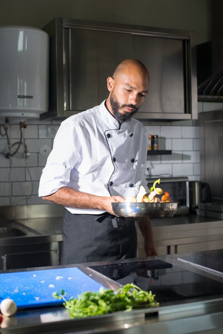 A Man In White Chef Uniform Cooking