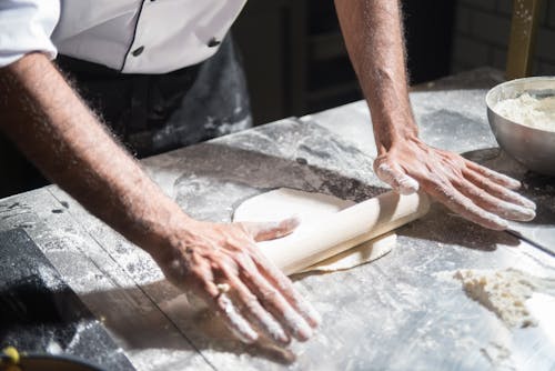 A Person Pinning the Dough Using Rolling Pin