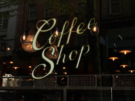 Warm coffee shop window with evening reflections and lights creating a cozy ambiance.