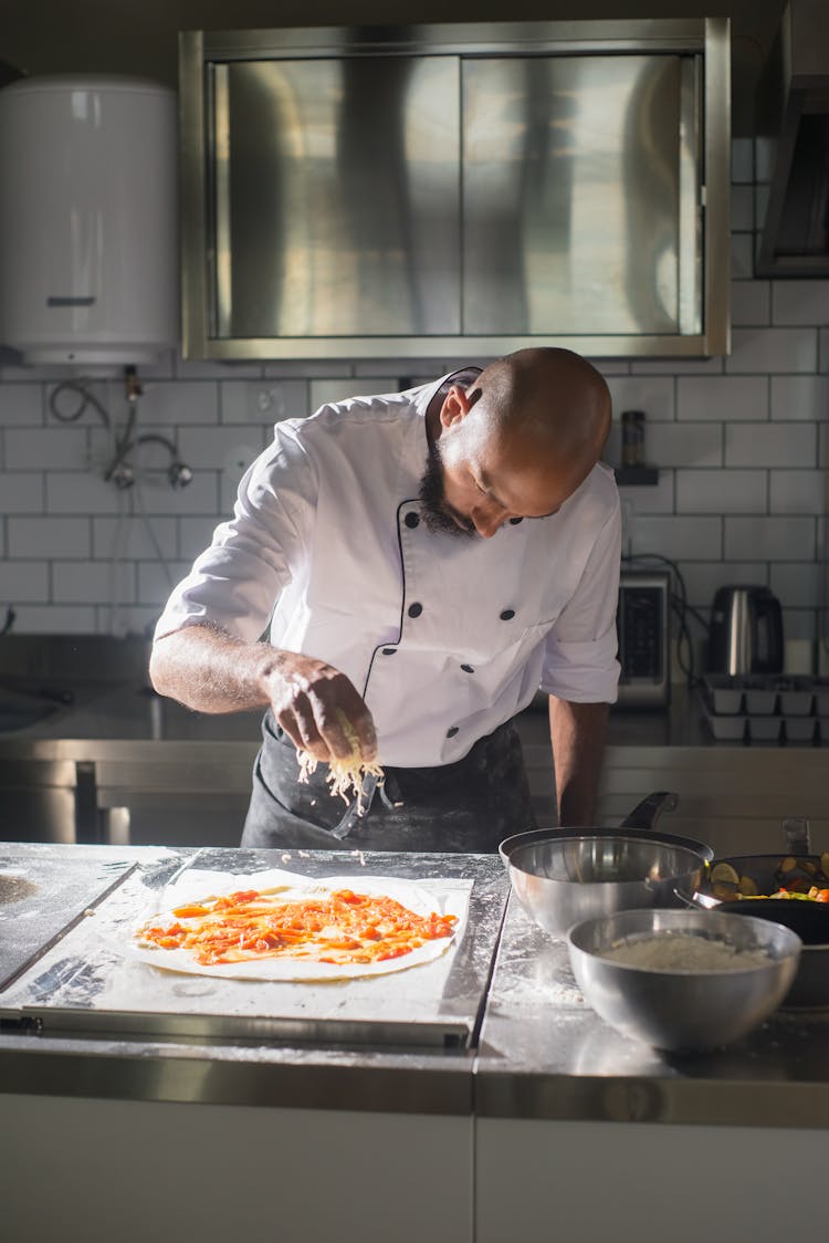 A Man Making Pizza In The Kitchen