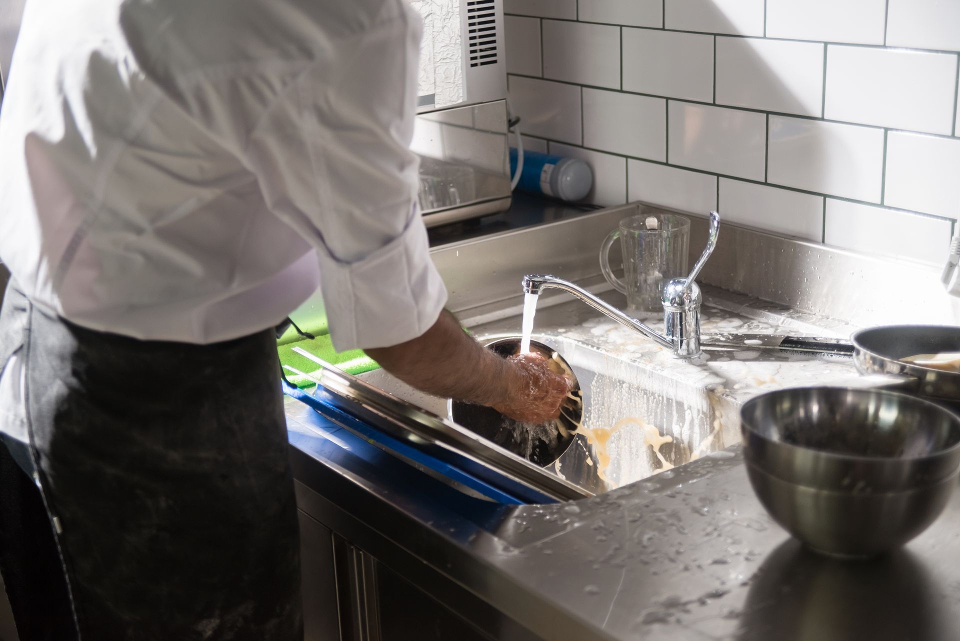 A Person Washing Dishes in the Sink
