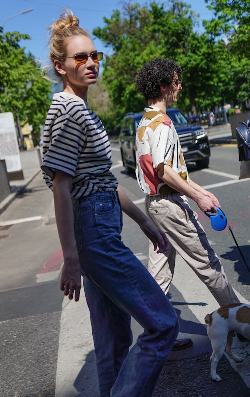 Woman in Striped Shirt Walking on Pedestrian Lane