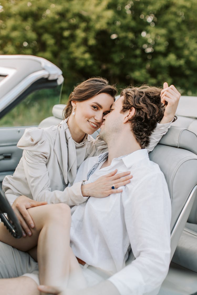 A Romantic Couple Kissing On The Car