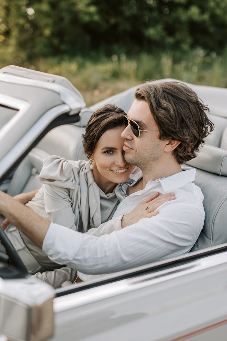 A Romantic Couple Sitting On The Car