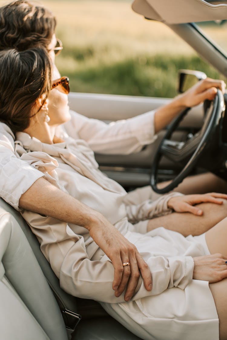 A Romantic Couple Sitting On The Car