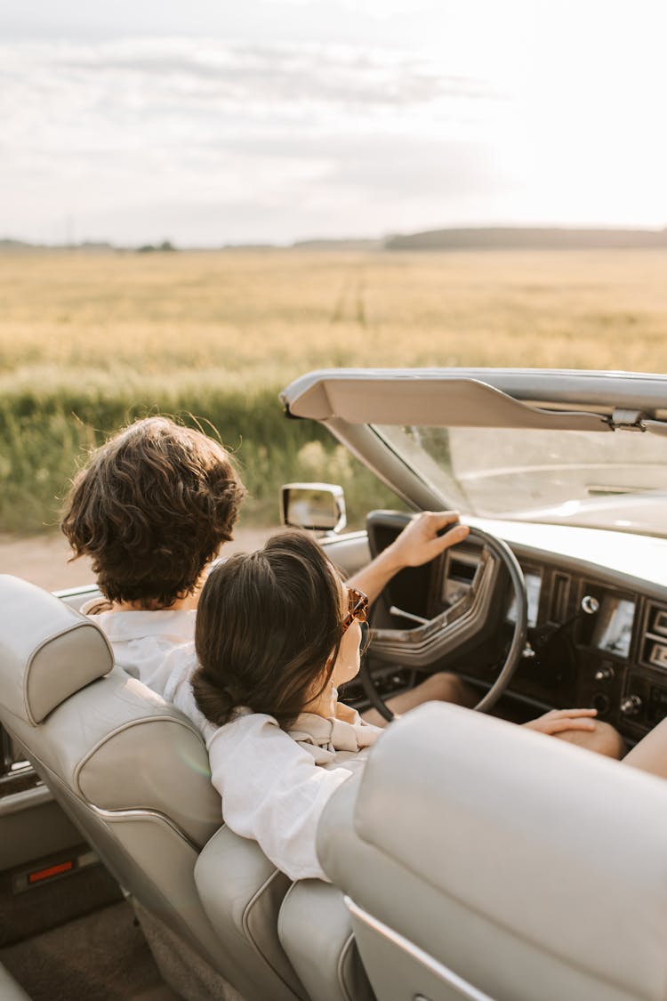 A Romantic Couple Sitting On The Car