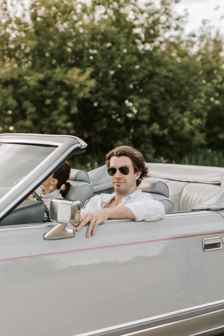 A Romantic Couple Sitting On The Car