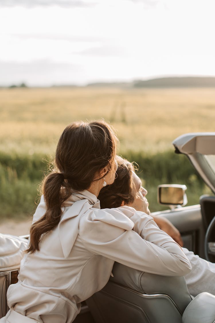 A Romantic Couple Hugging In The Car