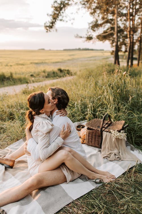 A Romantic Couple Hugging on a Grassy Field