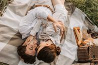 Man in White Dress Shirt Lying on Bed Beside Woman in White Dress Shirt