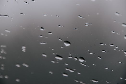 Close-up of water droplets on a foggy window capturing a rainy day mood.