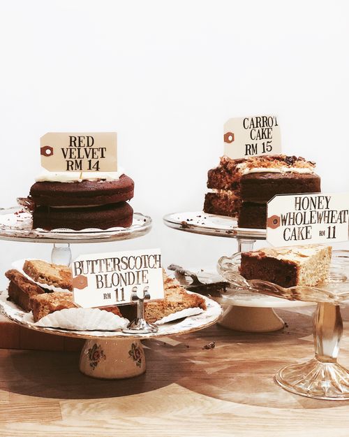 Free A variety of delicious cakes with price tags displayed on elegant stands. Stock Photo