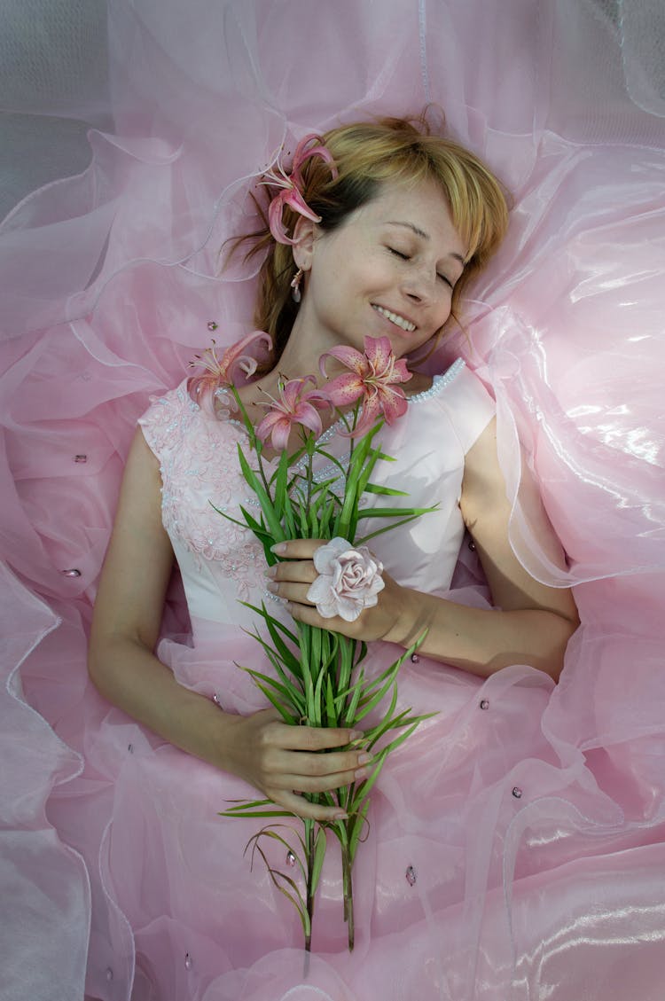 Dreamy Blonde Girl In White Dress Lying In Pink Tulle