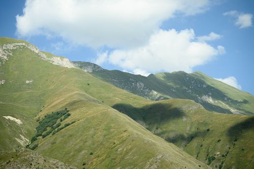 Free Scenic view of lush green mountains under a bright blue sky in North Ossetia, Russia. Stock Photo