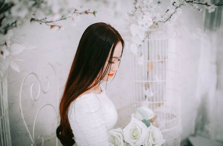 Woman Wearing Wedding Dress Holding Bouquet Of Flower