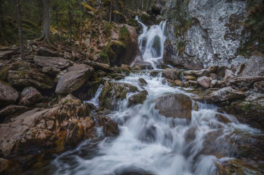 Tranquil waterfall cascading over rocks in the lush woods of Perm Krai, Russia.