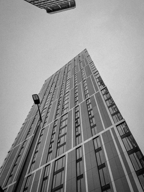 Monochrome view of a sleek high-rise building with geometric design elements.