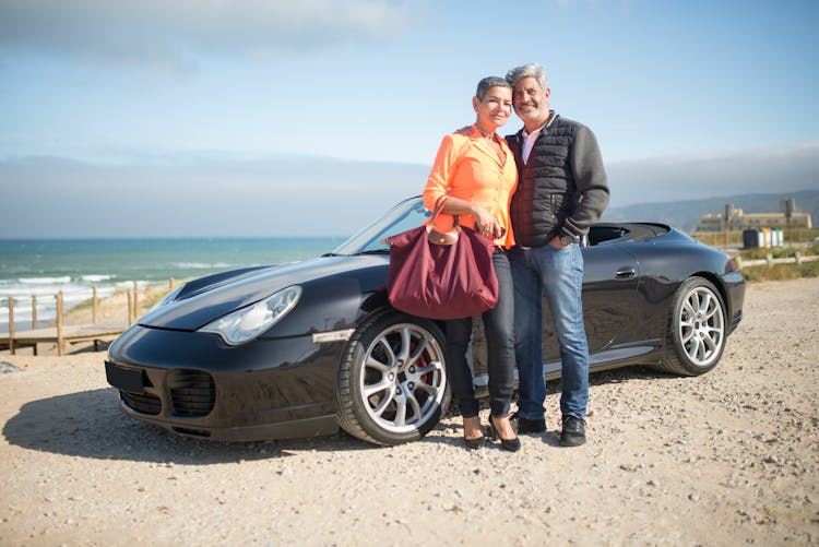 Couple Standing Beside Black Sports Car