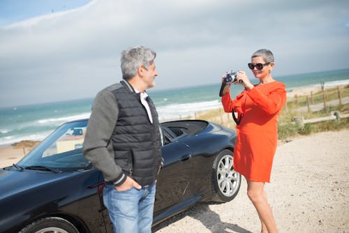 An Elderly Woman Taking a Photo of a Man Using an Analog Camera