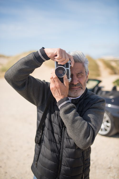 Man in Gray Jacket Holding Camera