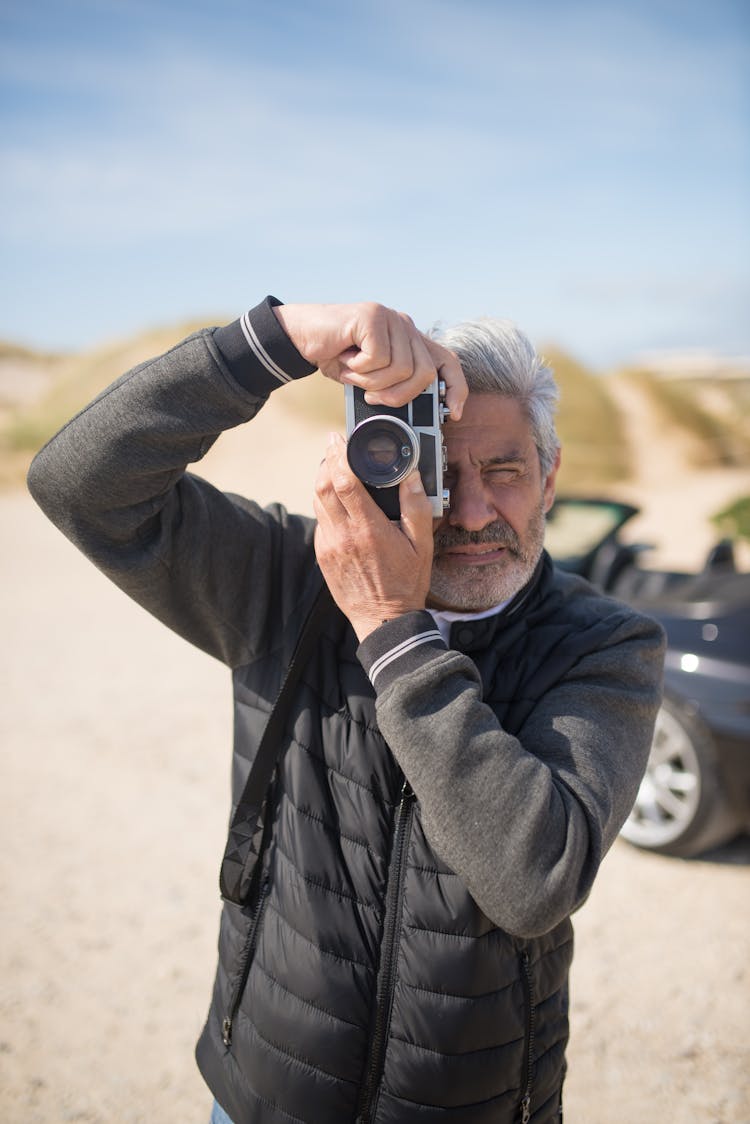 Man In Gray Jacket Holding Camera