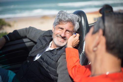 Free Senior couple smiling and enjoying a drive in a convertible by the beach in Portugal. Stock Photo