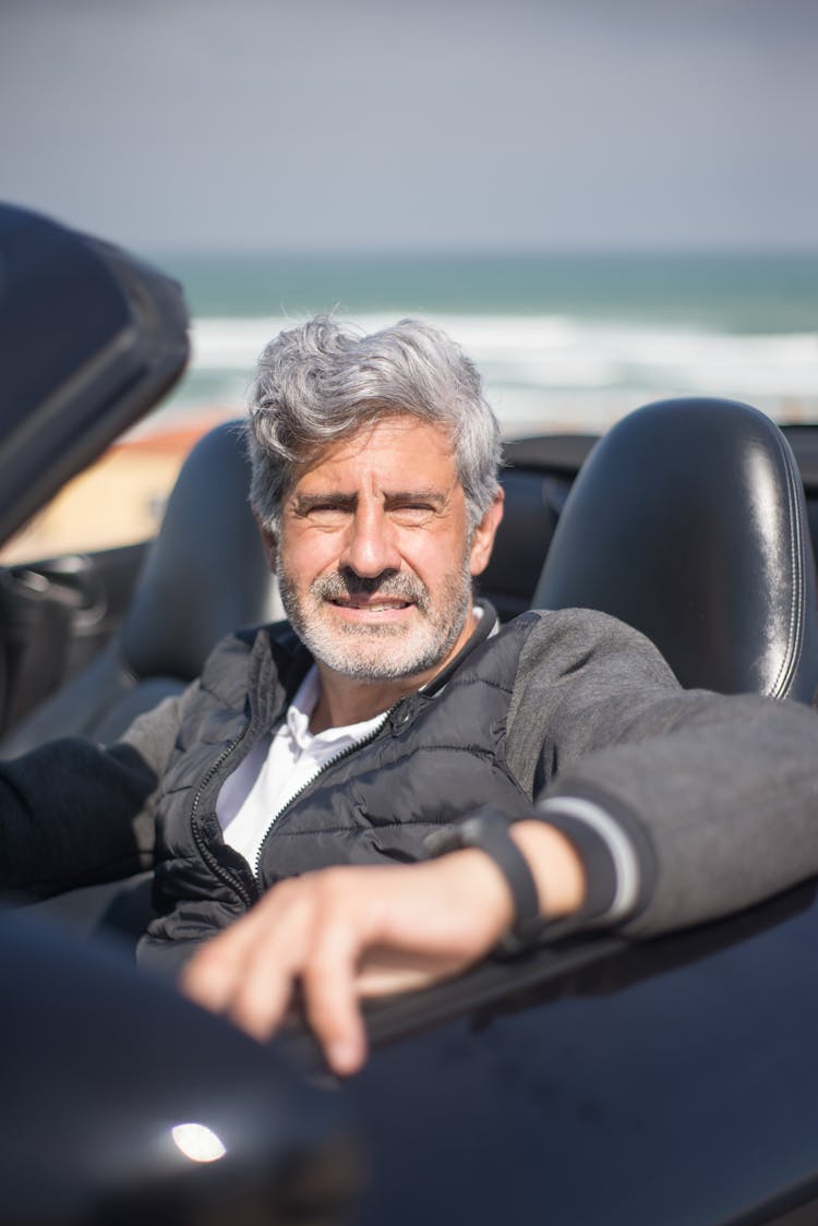 
A Bearded Man Driving A Convertible Car