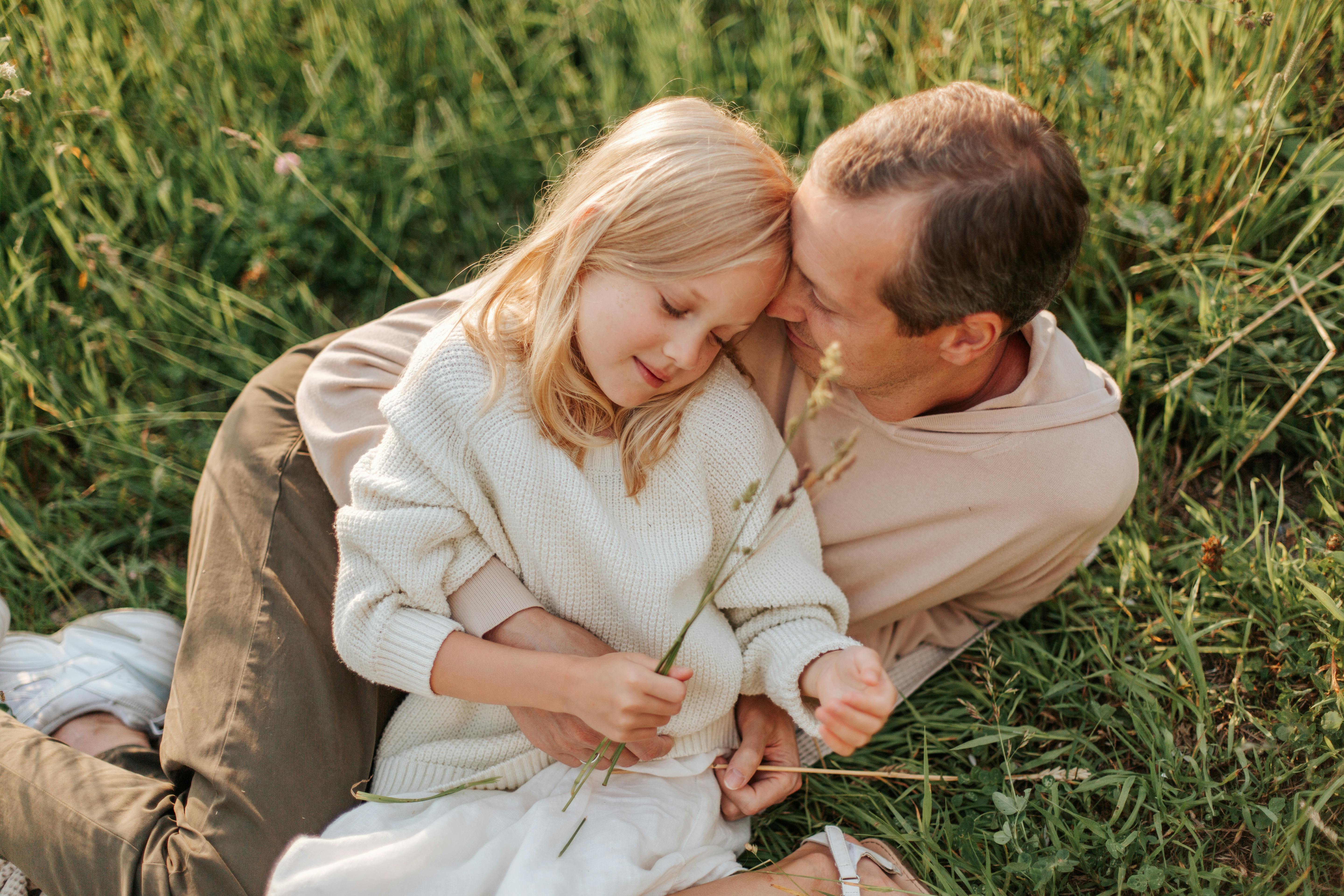 Father and daughter sitting together outdoors sharing a warm conversation